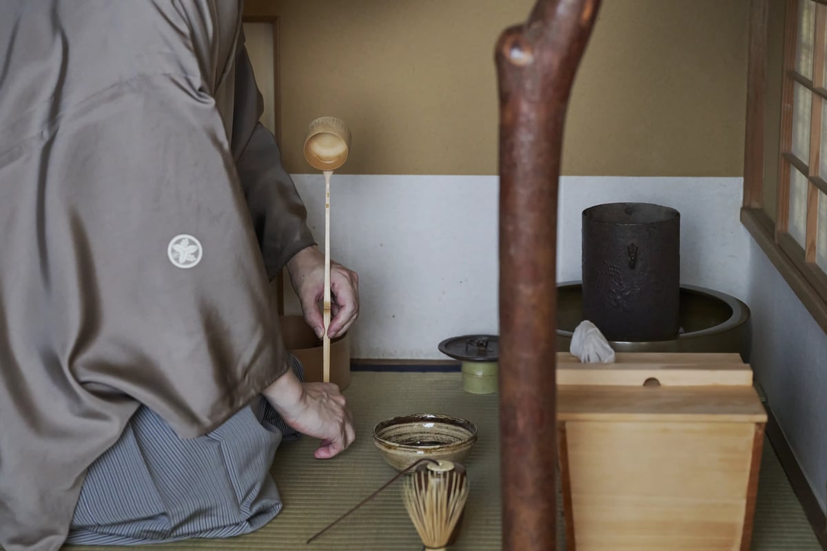 炉の前に座る亭主