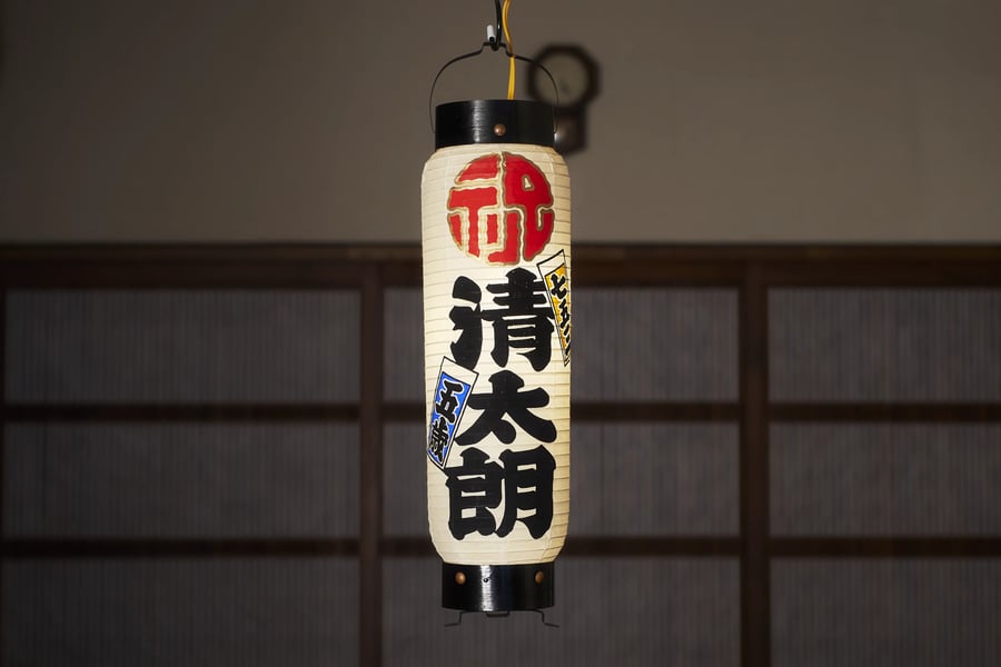 A tall lantern lettered with a name in black and red