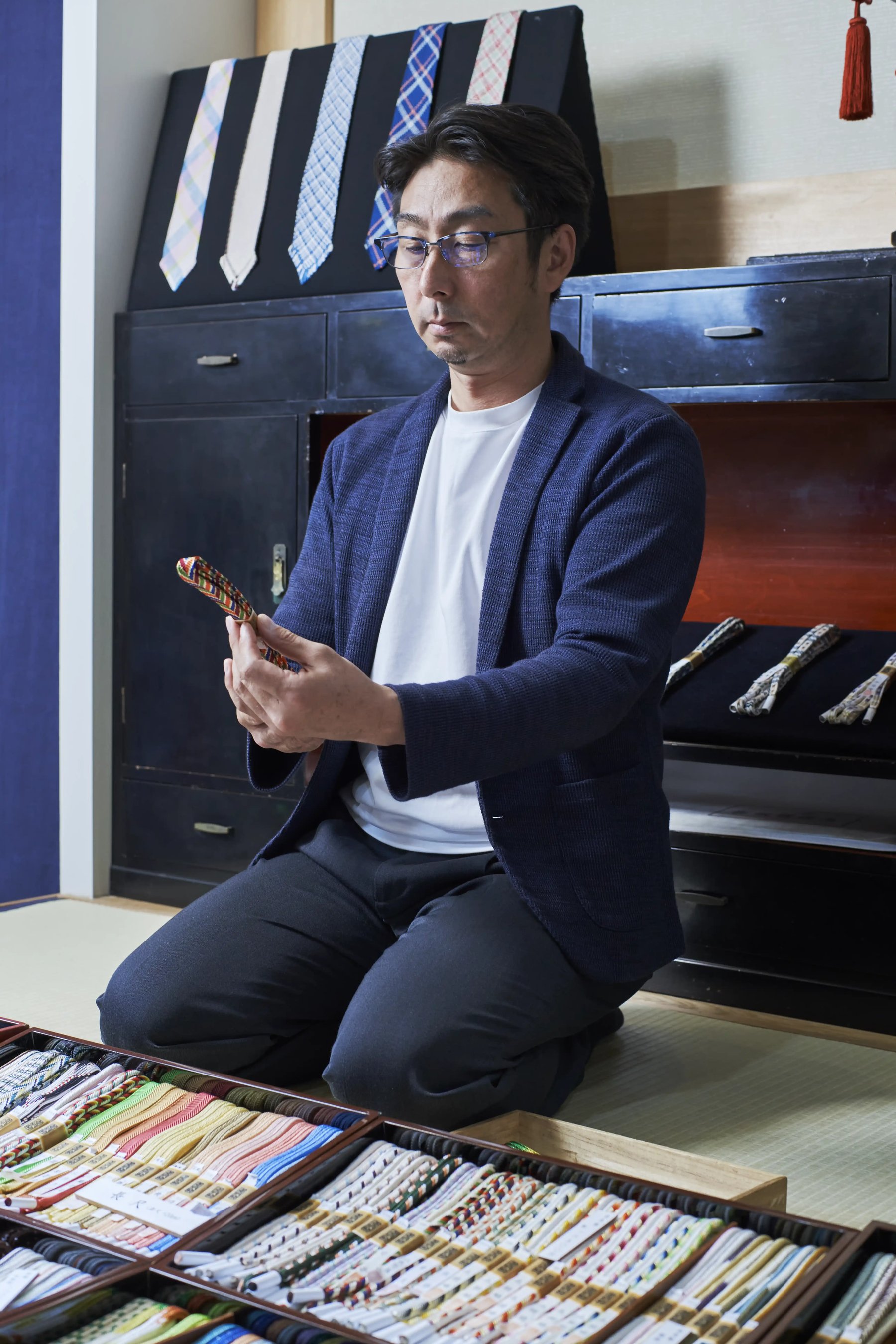 Kiichiro Domyo seated before rows of braided silk cord