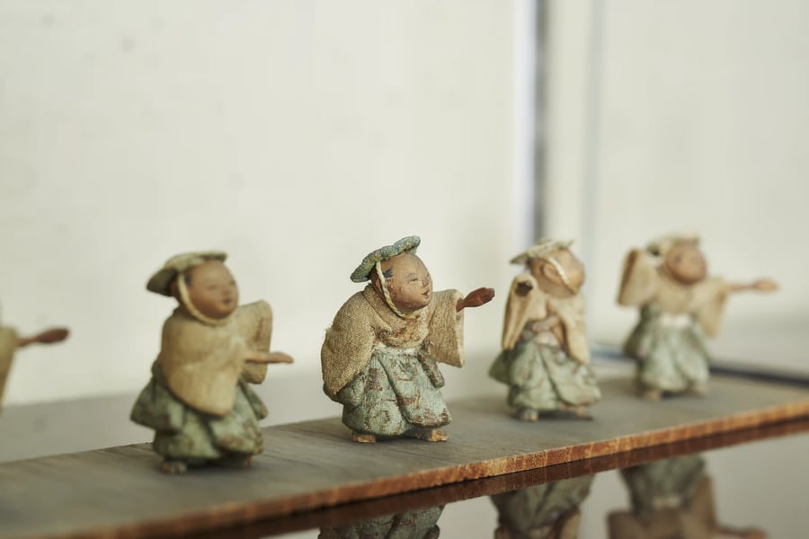 Small kimekomi figures on a lacquered shelf