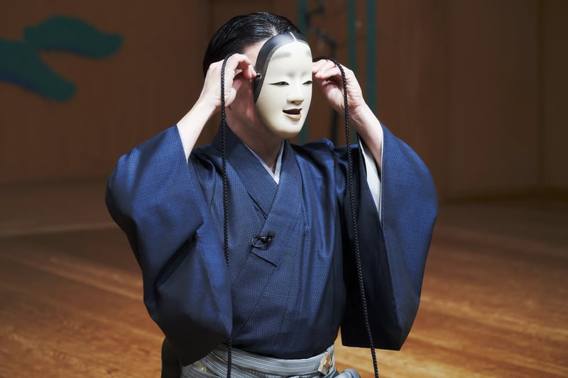 A noh mask lifted to the face