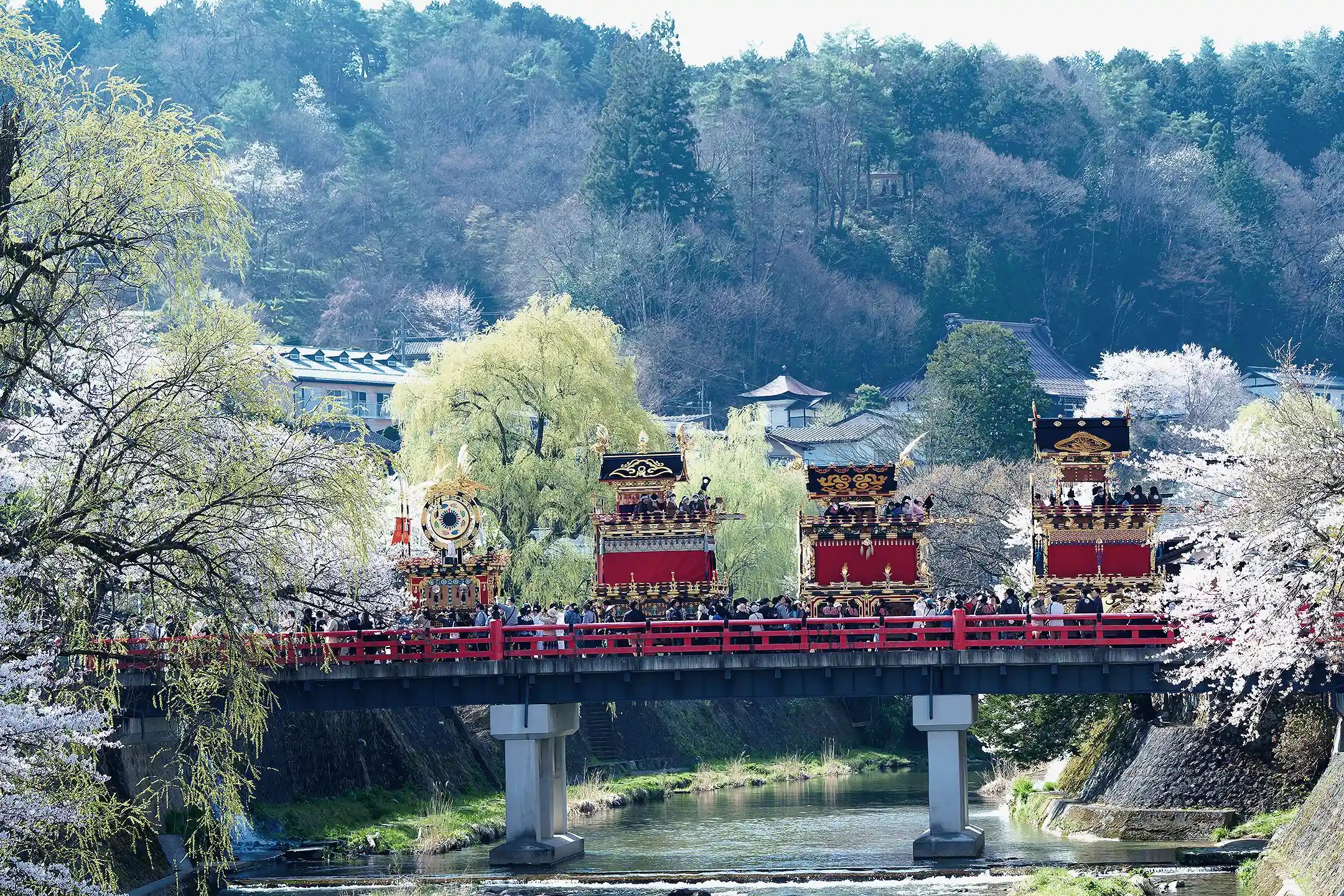Festival floats beside a red bridge