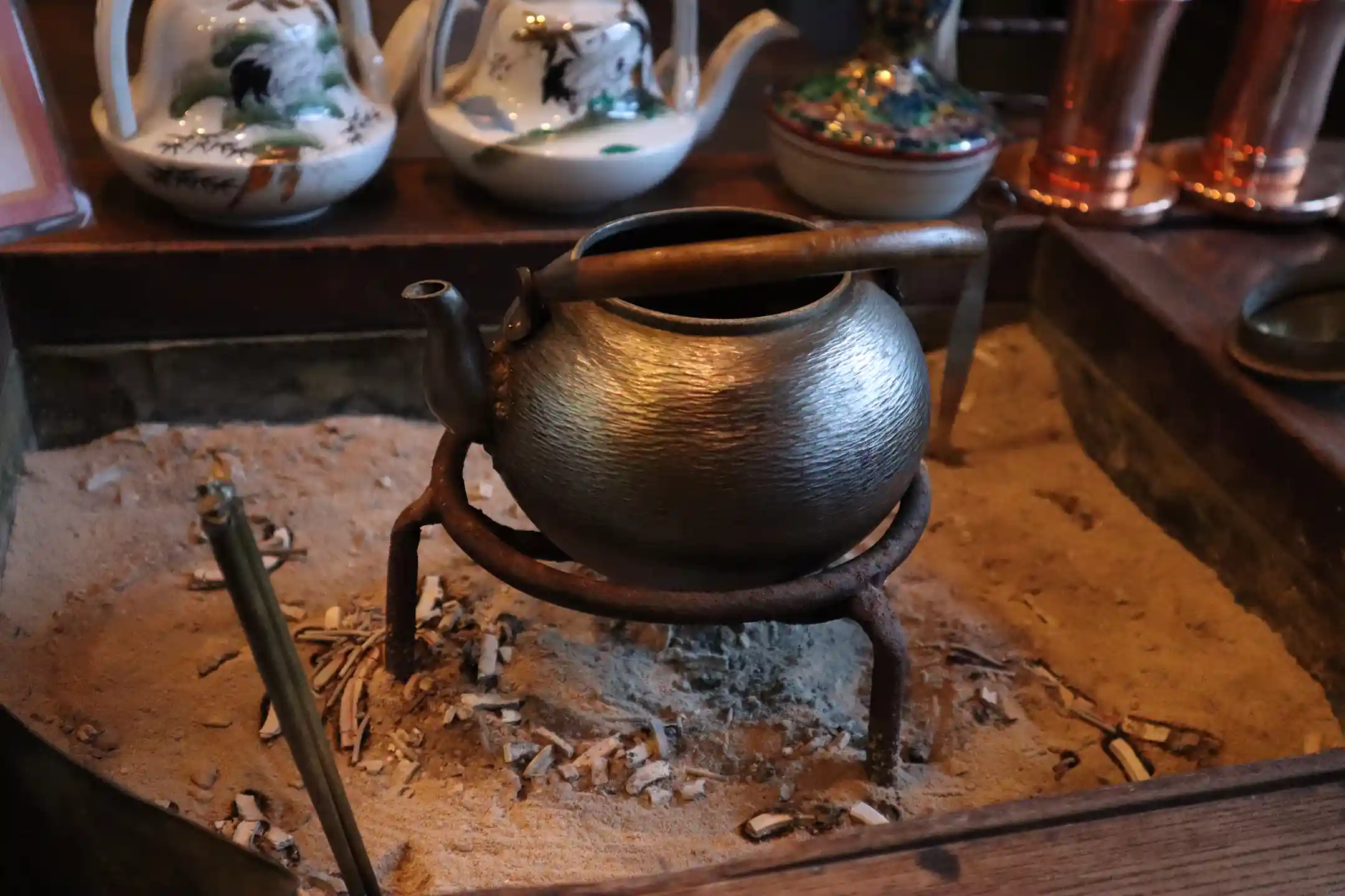 A Nambu ironware kettle over a hearth