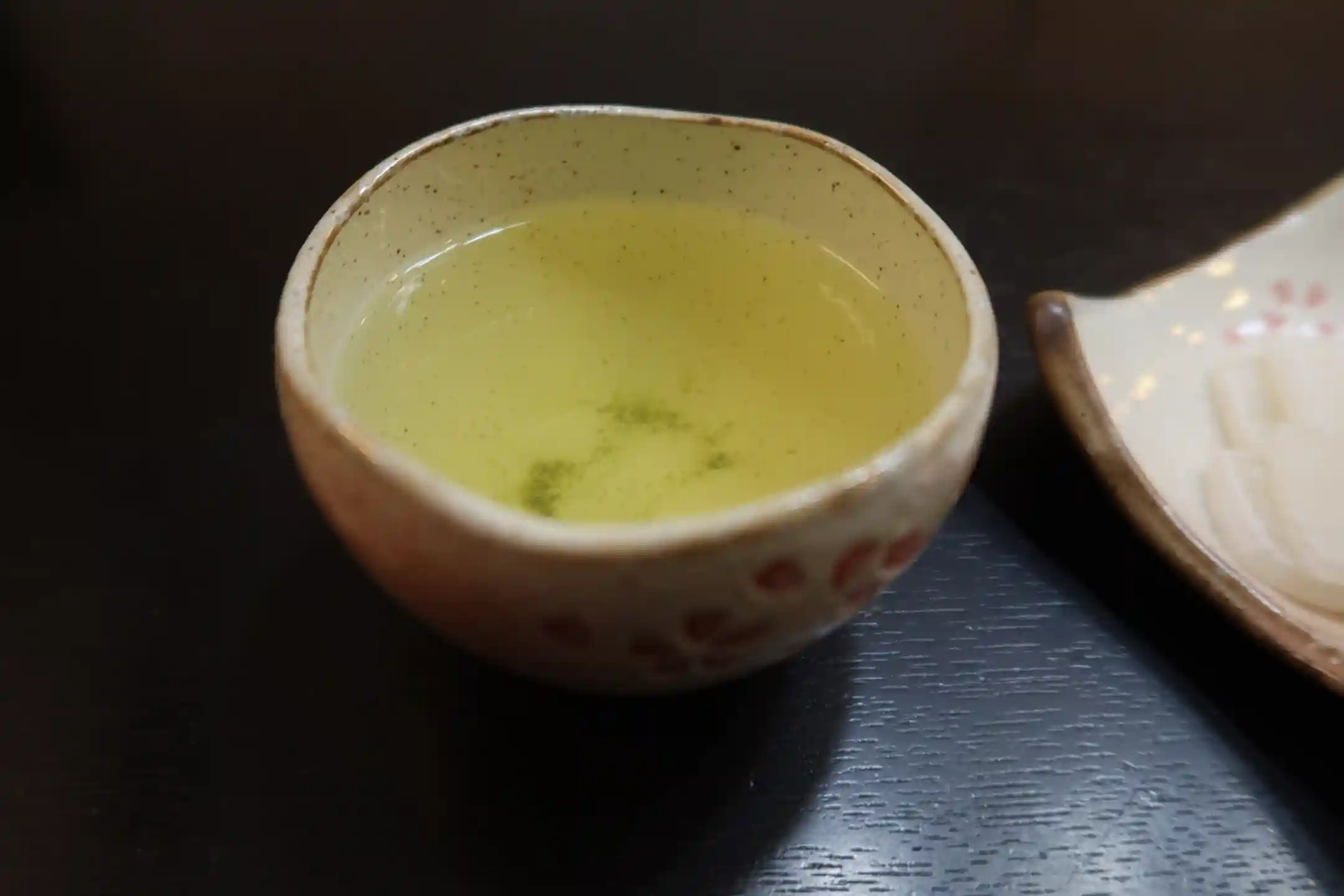 Loose tea leaves beside a cast iron kettle
