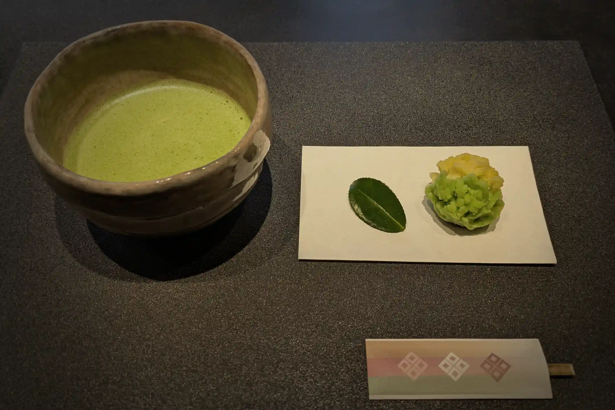A seasonal jo-namagashi sweet beside a bowl of matcha
