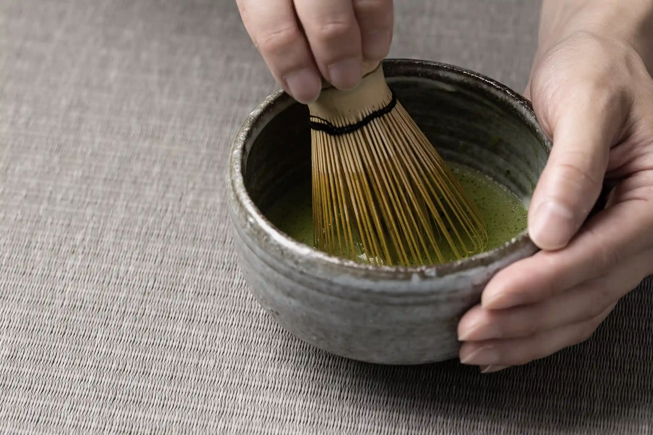 A bowl of matcha and a bamboo whisk