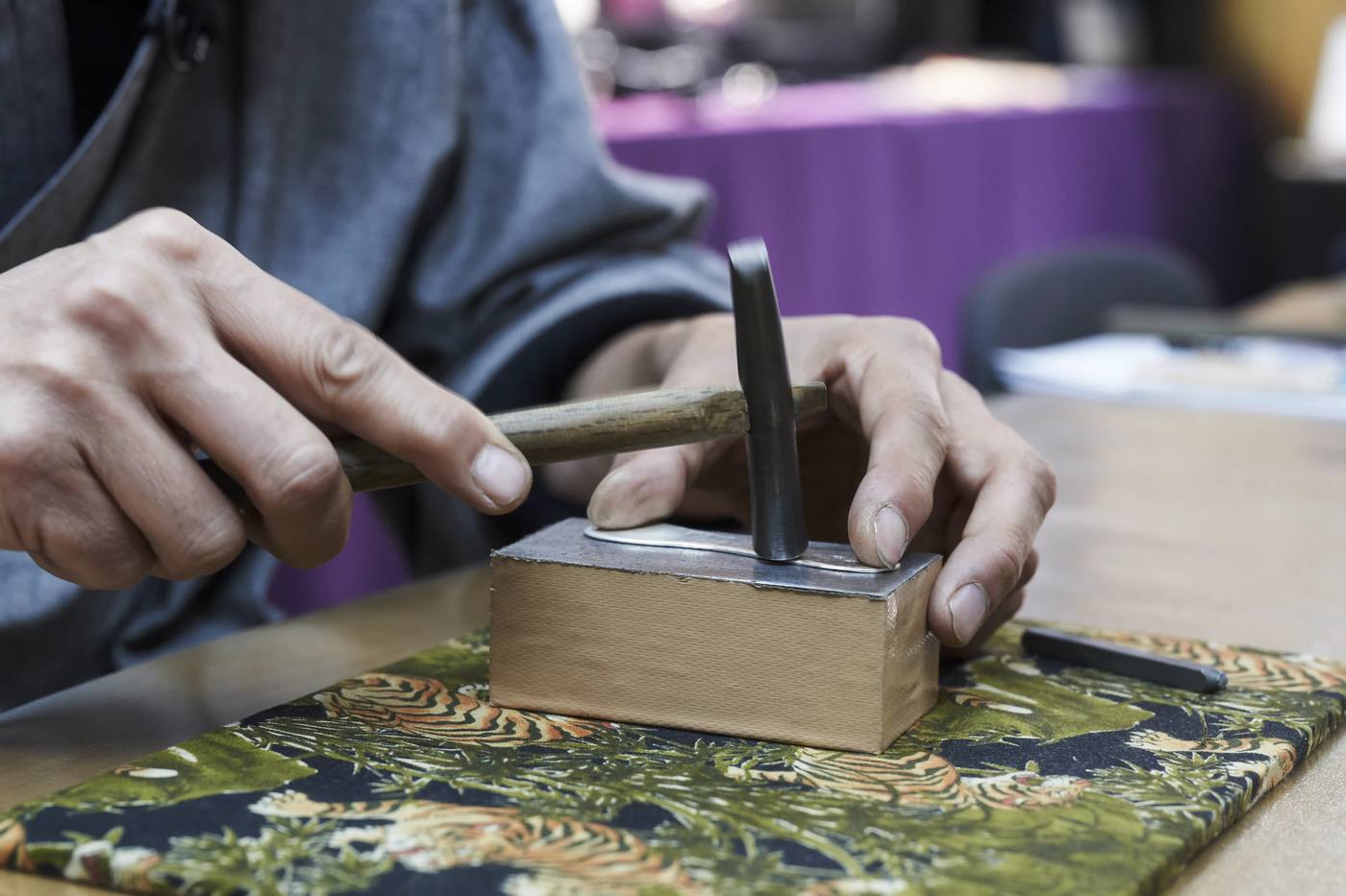 A chisel guided by hand across silver in a Tokyo workshop